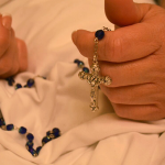 Hands praying a rosary