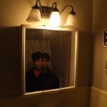 Photograph of boy looking into a split mirror