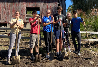 Students leaning on shovels