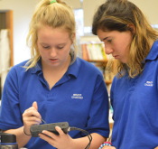 Students examining electronic circuit in science class